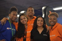 a group of young people in orange shirts posing for a photo